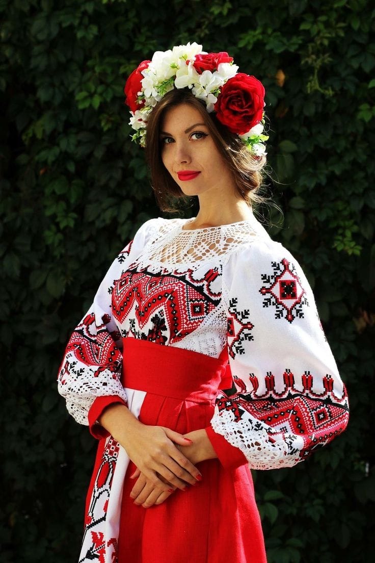 Femme en costume traditionnel slave brodé, couronne de fleurs rouges et blanches